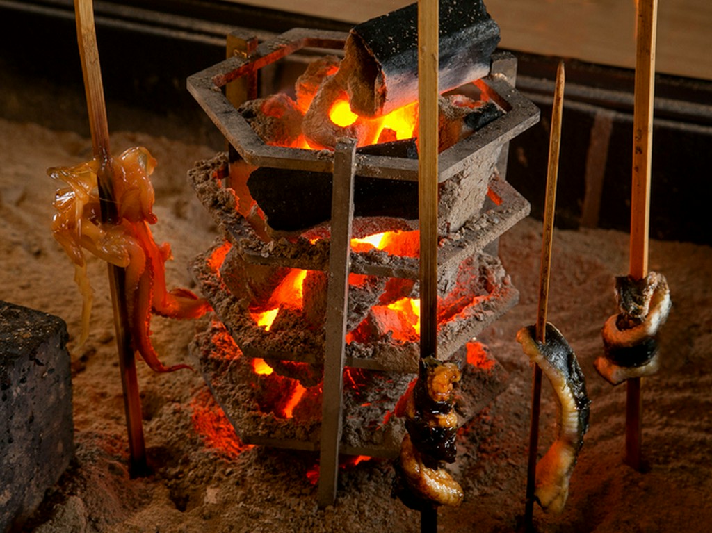 目の前で囲炉裏を使った調理風景を楽しめるカウンター席