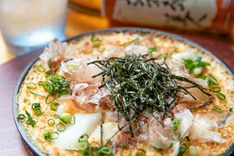 カツオと昆布の出汁つゆにつけて食べる。ふわとろの『海鮮山芋の鉄板焼き』