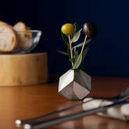 コースの前菜料理に先駆けて、お店から軽いご挨拶としての一品は種を抜いたグリーンとブラックのオリーブ。生花感覚のしつらえを眺めたら、パクっとひと口で。葉は本物のオリーブの葉です。