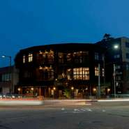 お店のロケーションは交差点の角地に建つレトロモダンな建物の2階。夕暮れ時にはガラスばりの建物全体がまるでランタンのよう。歴史的な薬局の建物をリフォームした味わいのあるフォルムです。