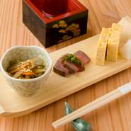 季節ごとの素材をつかった手づくりのお通しに、料理長のもてなしの心が表れています。白木の皿に盛られた粋な盛付けに気分も華やぎます。