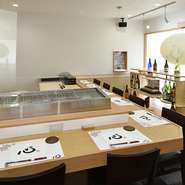 蘭と屋号をあしらったオリジナルのランチョンマットとひざ掛け、手拭きに季節の花と屋号をあしらったオリジナルの日本手拭いを使用（持ち帰りOK）。清潔感のある店内は、お手洗いにもちょっとした仕掛けがあります。