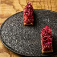 ユッケをイメージした一皿。サクサクな食感の生地の上には、やわらかなで甘味のある馬肉がのっています。プラムの甘酸っぱさと、赤く美しい色気のある見た目が、全体をシックにまとめています。