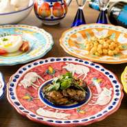 イタリアの空気感を漂わせる内装とともに、器使いにもシェフのこだわりが感じられます。南イタリアのかわいいお皿を中心に、色鮮やかな図柄が描かれた食器を使用。見ているだけで心が浮き立ちます。