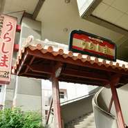 久米大通りに面しているわかりやすい店。ピンク色の看板と赤瓦が配された沖縄風の門がまさに竜宮城！