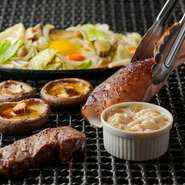 ジュー、パチパチ、という炉端焼きの音と煙も楽しい、臨場感あふれるオープンキッチンのカウンター。年季の入った昔ながらの風情が、どこか懐かしい気持ちにさせてくれます。初めて訪れても、ホッとできる空間です。