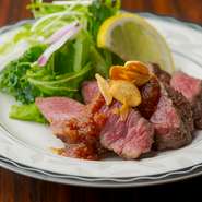 炉端で炙る能登牛はゆっくりとやわらかに熱せられ、とろけるような仕上がりに。ピーマンや玉ねぎなどを1週間以上熟成させて作った自家製チリソースでいただきます。