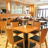 大きな窓から差し込む明るい光に開放感のある高い天井。安全な清潔感溢れる白いクッションタイルの店内はテーブル席の配置もゆったりしているので気兼ねせず寛げます。
