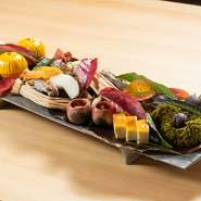 季節のプチキュイジーヌを八尾町の下尾デザインさんの一枚板に盛り込んだ季節感あふれるひと品です。