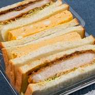 お持ち帰り用のサンドイッチとして人気です。【ブーランジェリーコチュウ】のパンに、柔らか三元豚カツの厚切り、養鶏業者から仕入れるタマゴも3個使っている贅沢サンドです。