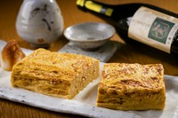 職人が一つ一つ絶妙な火加減で焼き上げる出汁巻き玉子は、お酒が進む濃いめの味わい。創業以来非常に評判の良い一品です。熊本県球磨の米焼酎『豊永蔵 完がこい』のやわらかな味わいと合わせて。