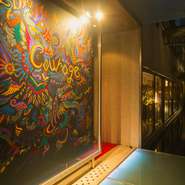 オーナーの相澤氏が細部までこだわりぬいた空間。「品のよい色気や艶っぽさ」を演出しています。赤・黒・ゴールドを基調に、どこかレトロな雰囲気を感じさせる店内。随所に若手アーティストの作品が飾られています。