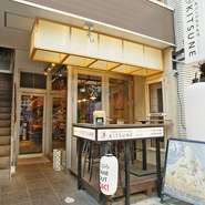 KITSUNEの看板とおおきな提灯が目印、黄色ののれんをくぐれば、オープンキッチンが目に飛び込みます。ショーケースには新鮮なネタが並べられ、目の前で揚げる天ぷらのライブ感が楽しめます。