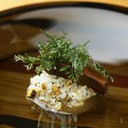 スプーンで食べられるほど徹底的に柔らかく煮込んだ牛タンの赤ワイン煮込み。その時々でバリエーションの違うリゾットが添えられています。写真はカヤの木の実を剥いて炒ったものを混ぜた香ばしい一皿。