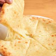 こだわりの小麦粉を使ってつくる自家製の『チーズナン』は、炭火を用いたタンドールで焼き上げます。炭火でこんがり焼いたナンのなかからとろとろのチーズが溶け出し、濃厚なおいしさが味わえます。