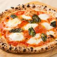 フレッシュモッツアレラ、バジル、トマトソースを使ったイタリアンカラーの王道ピッツァ。500度の石窯で焼く本格ナポリピッツァの中でも看板メニューです。熱いうちに召し上がれ