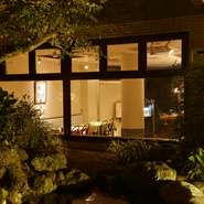 閑静な住宅街の一角にあるイタリアンレストラン。入口の扉までのアプローチには木々が繁り、季節の移ろいを感じさせてくれます。大きな窓から見える庭の風景を眺めながら、ゆったりと食事を楽しむことができます。