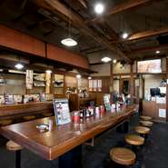 厨房から見渡せる広々とした空間。厨房前のカウンターでも相席カウンターでも、気軽にサクッと食事を堪能できます。昼休みはないので、お腹が空いた時に、いつでも一人でも、気ままに立ち寄れます。