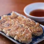 ひとつひとつ皮から手作りしています。中身の餡（あん）は、九州産のモモ肉を特性のタレで、ジューシーに仕上げています。　※にんにくは入れていません。ひとくち半餃子（5個）　230円