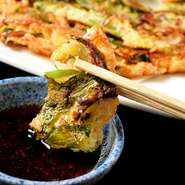 外はカリッ、中はもちっとした食感と香ばしい風味が食欲をそそる【焼肉コギチャン】のオリジナルチヂミ。海鮮・キムチ・エゴマの葉でリッチな気分を味わえる豪華版です。辛味のきいた自家製たれにつけてどうぞ。