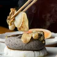 『万寿貝石焼き』は、【いしや】を訪れた人が必ず食べる名物料理のひとつ。熱く熱した天然石で、ゲスト自ら貝を焼けば、見事に踊る万寿貝を眺めることができるのも愉快な逸品。