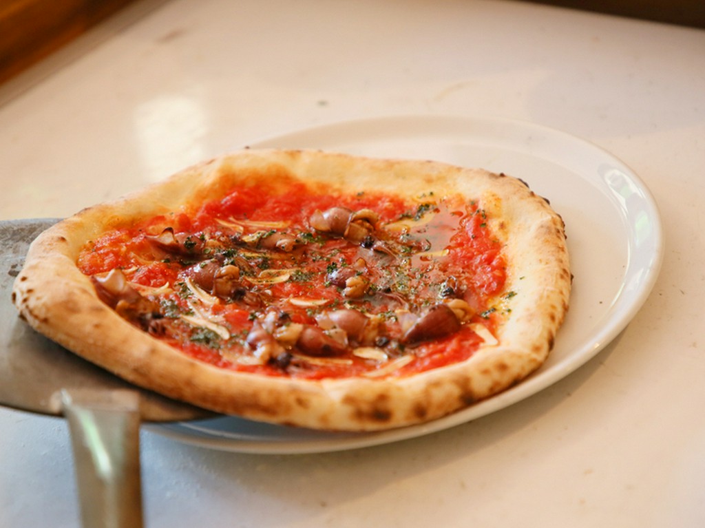 旬の野菜や魚介類をのせて薪窯を使い焼き上げる、ナポリの伝統的なつくりかたに則った『窯焼きピッツァ』