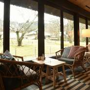 全面ガラス張りの、開放感のある空間。パリのカフェをイメージした、トリコロールカラーの映えるおしゃれな雰囲気です。春にはテラス席で、店名の通り「桜の樹の下で」ゆったりと食事を楽しむことができます。