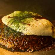 本場の広島流お好み焼き。定番の薄焼き玉子ではなく、ふわとろオムレツをのせた【弁兵衛】のオリジナルの一品です。麺は広島から直送、ソースは、おたふくソースと共同開発のオリジナルソース。