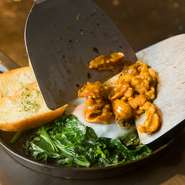 ほうれん草のバターソテーの上に、半熟玉子をのせ、その上にうにソースで軽く炒めて風味をアップさせた「うに」をのせた贅沢な逸品。弱火でこんがりと焼いたガーリックトーストと相性抜群です。