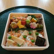 折箱の中には、桜が満開。
手に持ちやすく、外でも食べやすい折箱に、春の料理がぎっしり詰まっています。