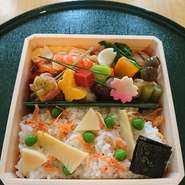 折箱の中には、桜が満開。
手に持ちやすく、外でも食べやすい折箱に、春の料理がぎっしり詰まっています。