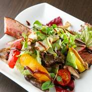 自家製ベーコンは、1週間かけ塩漬けから燻製まですべて手づくり。脂身が少ない豚バラを選び、しつこすぎず旨みをしっかり楽しめる逸品に仕上がっています。ボリュームがあるので食事サラダとしてもおすすめです。