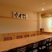 テーブルは愛知県の宮大工がつくった米ヒバの一枚板。額は「雪月花」。陶芸家の辻村史朗氏によるもの。
