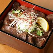 黒毛和牛カルビをたっぷり味わうお重箱。タレの染み込んだお肉とお米がたっぷり詰まっています。温泉卵やレモンで味にアクセントを加えることで、いろいろな角度から黒毛和牛を楽しめます。