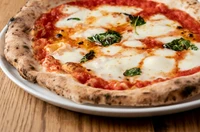 イタリア製の本格薪窯を店内に設え。約500℃の高温で一気に焼き上げるので、生地のサクサク感と香ばしさが絶品。モッツァレラの最高峰・水牛のチーズを使った『マルゲリータエキストラ DOC』も大好評です。