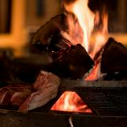 焚き火を囲ってぐるりとカウンターが設置され、その中でお肉やその他の料理が出来上がる様子を見ながらお過ごしいただけます。