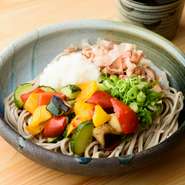 ズッキーニ・赤ピーマン・黄ピーマン・ナスをグリルし、出汁で軽く湯がいたものをたっぷりトッピング。野菜たっぷり、華やかな見た目で女性に人気です。大根おろし・葱・花かつおと合わせて。