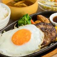 お店で不動の人気を誇る『鉄板ハンバーグ定食』。お肉はあえて粗びきにすることで、肉肉しい食感を実現。トッピングされた目玉焼きと共に、食べ応えも抜群の逸品。ぜひとも食べてみたいひと品です。