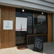 住宅地に馴染む落ち着いたガラス張りの店構え。その日仕入れた“逸魚”による黒板メニューが目を引きます。