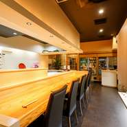 一歩店内に足を踏み入れると、料理人たちの姿を間近で堪能できるカウンターがお出迎え。和をテーマに洗練された佇まいの店内。木目にブラックがアクセントを利かせています。