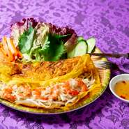 現地ではバインセオとして呼ばれるベトナムの郷土料理。豚肉やエビ、もやしを皮で包んで食べるスタイルです。ナンプラーなどを使って作る自家製タレを付けると、食欲が一層増します。