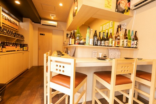 カウンター前に、酒瓶がずらり。珍しい日本酒や焼酎も揃う