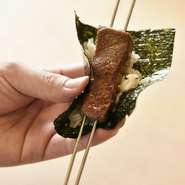 炭火でサッと炙ったトロを海苔とご飯でくるりと巻いて供されます。「温かい」と「冷たい」を同時に味わえる、温度差が楽しい変わり寿司です。新鮮なトロに炭火の香ばしさが加わり、刺身とは一味違った味わい。