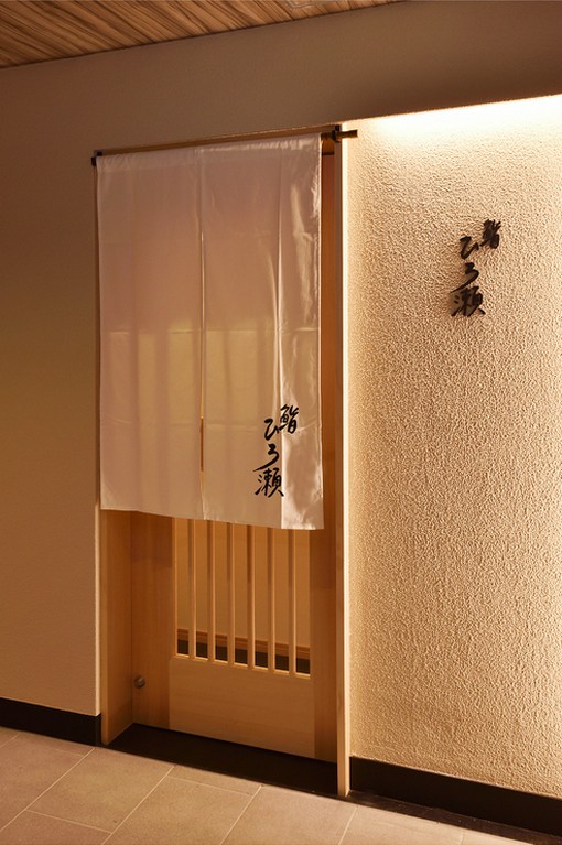 無駄のない端正な店構えに、壁や木材の質感が趣きをプラス