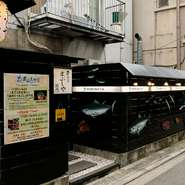 カウンターに設置されたネタケースには、本日おすすめの魚が並べられています。ゲスト自らがその目で鮮度を確認することが可能。また店舗の外観にはさまざまな魚が描かれ、インパクトがあります。
