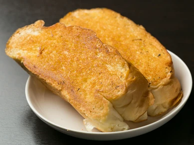 肉の旨みをたっぷりと吸って濃厚な『ガーリックトースト』