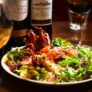 鮮やかな甲羅で、グリーンのサラダに彩りを添えるオマール海老。丸々一尾使うことで、サラダがいっそう華やかになります。自家製ドレッシングが野菜と海老をひとつにまとめてくれます。