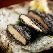 豚のロース肉を、黒ごま・醤油・みりん・三枚肉の出汁を配合した漬けダレに入れ寝かせ、味を染みこませています。さらに、黒ごまをまぶしてから蒸していくため、しっとりと柔らかい肉質に。