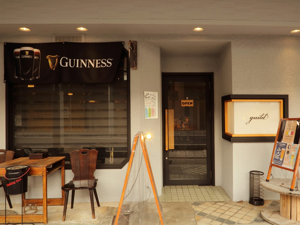 店の外では喫煙OK。白と茶を基調としたシックなエントランス