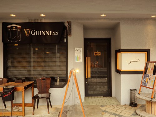 店の外では喫煙OK。白と茶を基調としたシックなエントランス